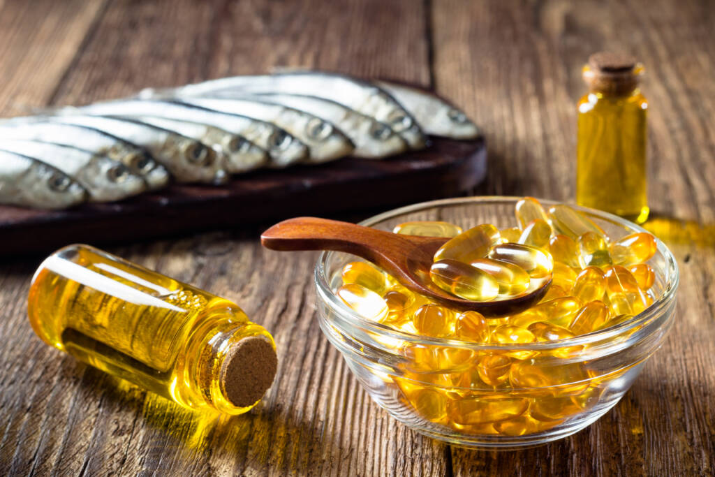 Fish oil capsules on wooden background, vitamin D supplement - TASG Naturals